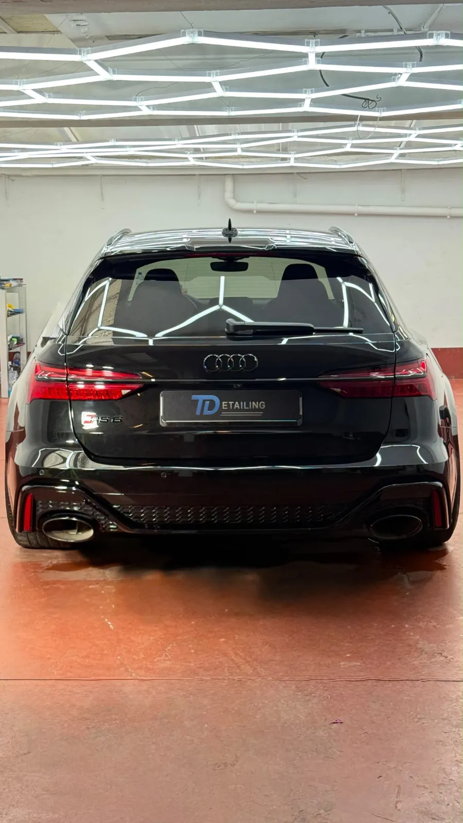 Achterzijde van een Audi RS6 onder studiolicht bij auto detailing